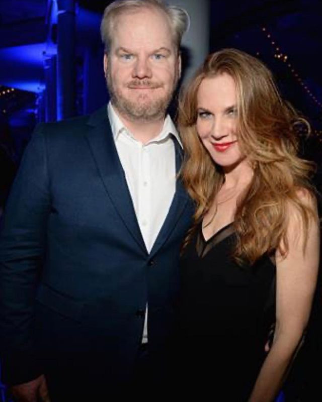 Jim Gaffigan in a black formal dress with his wife in a black top.
